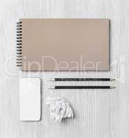 Notebook, smartphone, pencils, crumpled paper
