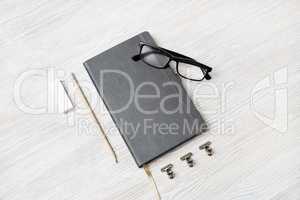 Notebook, glasses, pencil and eraser