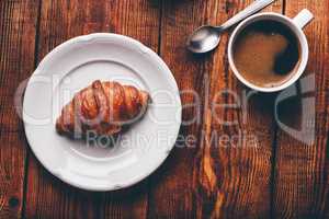 Cup of Coffee And Croissant on Rustic Table