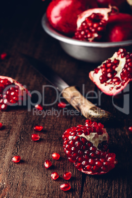 Pomegranate pieces on rustic wooden surface