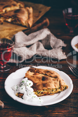Slice of cabbage pie with sour cream sauce