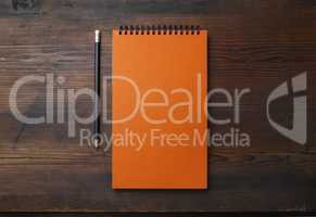 Orange notebook, pencil