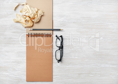 Notebook, glasses, pencil, crumpled paper