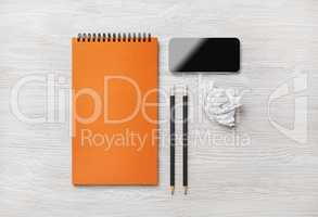 Notepad, smartphone, pencils, crumpled paper