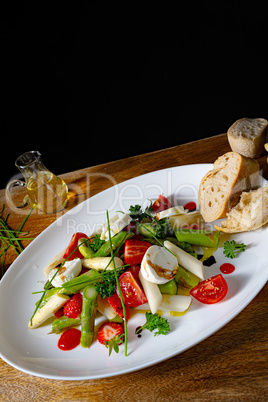 Asparagus salad with strawberries, tomatoes and goat cheese