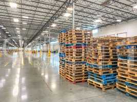 Massive Empty Industrial Warehouse Interior With Stacked Pallets