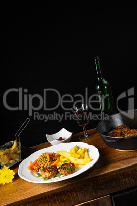 Homemade meatballs with french fries and vegetables