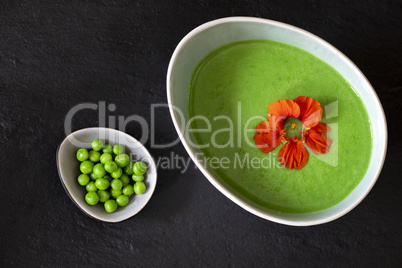 cremige Erbsensuppe auf schwarzem Schiefer