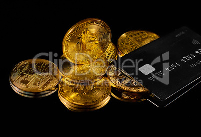 Golden coin with bitcoin logo and credit card . Leader in cryptocurrency BTC and bitcoin rewards card against black surface. Decentralized digital currency. Crypto payment. Electronic money or e-cash