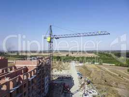 Crane on a background of blue sky at the construction site. New buildings in the city.