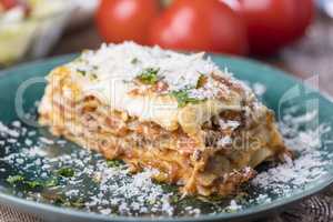 Portion Lasagne auf einem grünen Teller