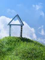 House made of books on a small grassy hill