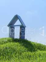 House made of books on a small grassy hill