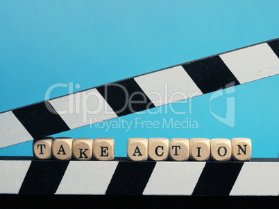 Small wooden blocks with the inscription Take Action on a clappe