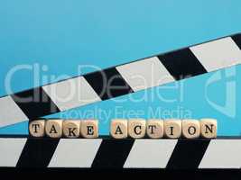 Small wooden blocks with the inscription Take Action on a clappe
