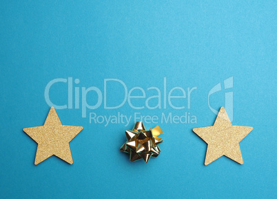 Christmas background with golden stars and bow on blue