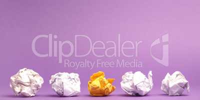 Colorful crumpled paper balls on a purple studio background