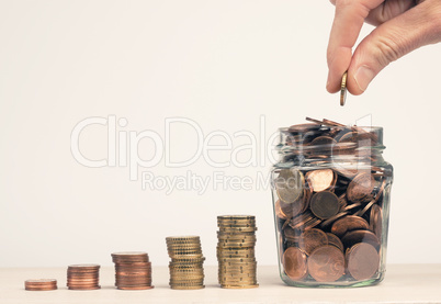 Stacked money coins in the form of a staircase to a jar filled w