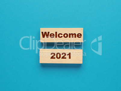 Two wooden blocks with the inscription Welcome 2021 on a blue ba