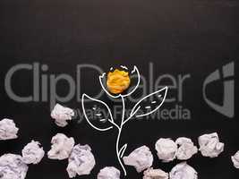 Concept for new ideas, yellow crumpled paper grows up as a flowe