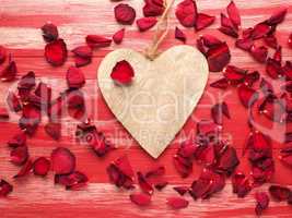 Rustic wooden heart with rose petals on wood