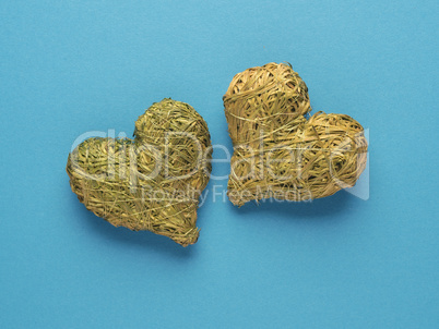 Two hearts made of straw on a blue background