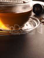 Tea glass with organic chai tea on a stone table, close up