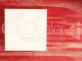 Invitation concept with a blank canvas on a red wooden backgroun
