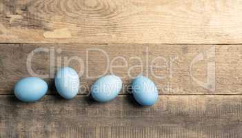 Naturally colored organic eggs in a row on a rustic table