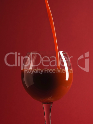 Pouring fresh organic tomato juice in a glass