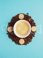 Cup of tasty coffee on coffee beans with cookies turns clockwise