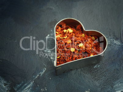 Hot organic chili flakes in a heart shaped cookie cutter