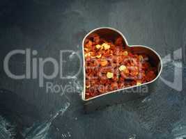Hot organic chili flakes in a heart shaped cookie cutter