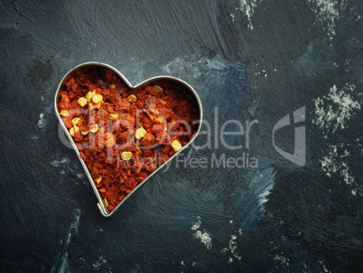 Hot organic chili flakes in a heart shaped cookie cutter, top vi