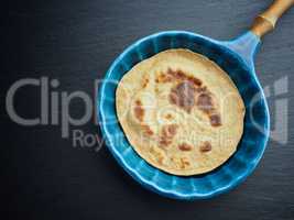 Delicious spelt pancake in a blue stoneware pan, too view