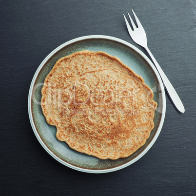 Delicious spelt pancake on a blue stoneware plate, too view