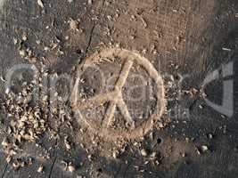 The peace symbol carved in wood with chisels. Peace concept, glo