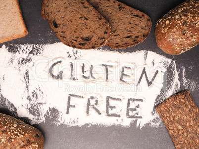 Gluten free written in flour with different types of bread as de