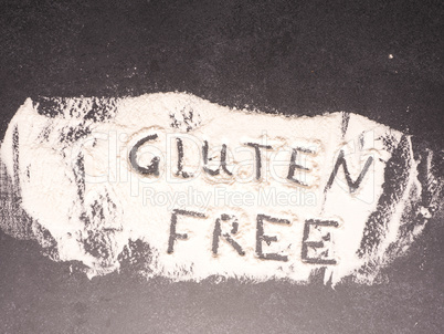 Gluten free written in flour on a dark stone kitchen table