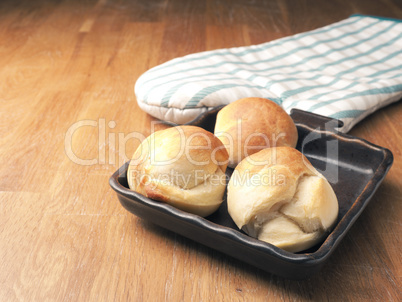 Baked yeast dough balls in a ceramic pan in a kitchen