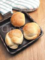 Baked yeast dough balls in a ceramic pan in a kitchen