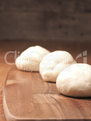 Yeast dough balls on a cutting board in a kitchen