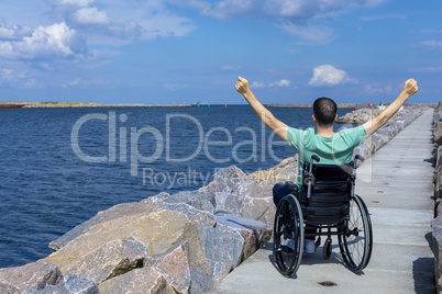 Disabled man in a wheelchair at the sea