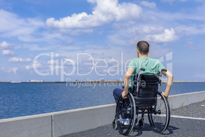 Disabled man in a wheelchair at the sea