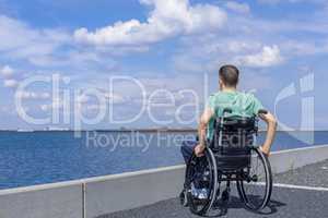 Disabled man in a wheelchair at the sea