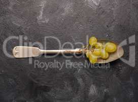Fresh organic grapes on a rustic spoon on a dark background