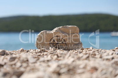 Stone with pictogram from numbers on the beach