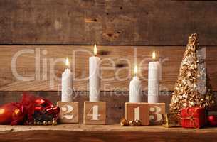 Fourth Advent candle burning on a rustic wooden table