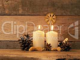 Second Advent candle burning on a rustic wooden table
