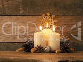 Third Advent candle burning on a rustic wooden table